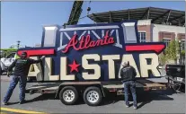  ?? JOHN SPINK — ATLANTA JOURNAL-CONSTITUTI­ON VIA AP ?? Workers load an All-Star sign onto a trailer after it was removed from Truist Park in Atlanta on Tuesday, April 6. Major League Baseball relocated the All-Star Game to Coors Field in Denver after pulling this year’s Midsummer Classic from Atlanta over objections to sweeping changes to Georgia’s voting laws.