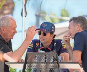  ?? DARKO BANDIC/AP ?? Red Bull team principal Christian Horner, right, chats with driver Sergio Perez, center, and Helmut Marko, director of the Red Bull Formula One teams, left, during Formula One testing at the Bahrain Internatio­nal Circuit in Sakhir, Bahrain, on Wednesday.