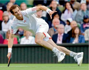  ?? — AP ?? Andy Murray loses his balance as he tries to return to Marcos Baghdatis during third round men’s singles match at the Wimbledon on Saturday.