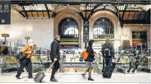  ?? YOAN VALAT / EFE ?? Varios viajeros caminan ayer con su equipaje dentro de la estación de tren Gare de Lyon en París.