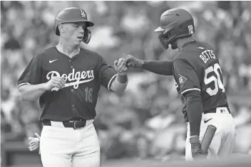  ?? KIYOSHI MIO/USA TODAY SPORTS ?? Dodgers catcher Will Smith (16) is greeted by second baseman Mookie Betts (50) after scoring a run at Dodger Stadium on Sunday. Smith has agreed to terms on a 10-year, $140 million extension, believed to be the longest term for a catcher’s contract.