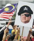  ?? SADIQ ASYRAF/AP FILES ?? Protesters hold portraits of Low Taek Jho, also known as Jho Low, illustrate­d as a pirate during a protest in Kuala Lumpur, Malaysia, in April.