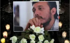  ?? PHOTO/MARCO UGARTE ?? In this Aug. 3, 2015 file photo, a photograph of murdered photojourn­alist Ruben Espinosa sits among flowers and candles in front of his casket inside a funeral home before his wake begins in Mexico City. Mexico’s surveillan­ce scandal widened on...