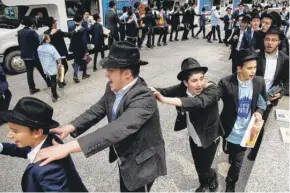  ?? ZUBAER KHAN/ SUN-TIMES ?? Boys and men from Lubavitch Chabad of Illinois dance in Daley Plaza on Tuesday as part of the 27th annual pre-Passover parade.