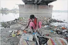  ?? ALTAF QADRI THE ASSOCIATED PRESS ?? Ram Nath, 40, sorts reusable trash he fished out from Yamuna, India’s sacred river that flows through the capital of New Delhi.