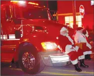  ?? Westside Eagle Observer/MIKE ECKELS ?? The siren on this Decatur Fire Department pumper truck announces the arrival of Santa and Mrs. Claus as they travel down Main Street in Decatur Friday night on their way to City Hall to meet kids up close and personal.