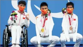  ?? ZHANG CHENG / XINHUA ?? Zheng (center) poses with Ruan Jingsong (left) and Wang Lichao after winning medals in the men’s 50m backstroke S5 category heat during the Games in Japan on Aug 30.