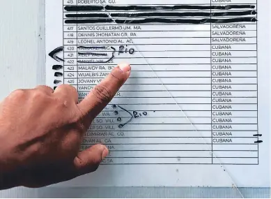  ?? FOTO: AP ?? Un migrante en Matamoros, México, revisa una lista de personas que han pedido asilo en EE UU y que esperan ser llamadas para una primera entrevista. Los nombres tachados ya fueron llamados.