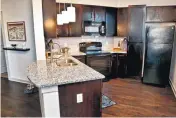  ??  ?? Granite kitchen counters are among the high-end features in the upscale townhome apartments at J Marshall Square, by Gardner Tanenbaum Holdings.