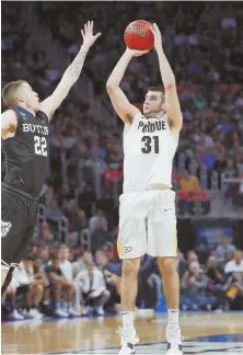  ??  ?? SHOOTING START: Dakota Mathias shoots a 3-pointer over Butler’s Sean McDermott to lift the Boilermake­rs to victory yesterday.