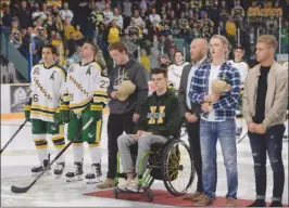  ?? The Canadian Press ?? Returning Humboldt Broncos players Brayden Camrud (26) and Derek Patter (23), far left, along with former other teammates, stand for the playing of the national anthem during a pregame ceremony before their SJHL season home opener on Wednesday night.