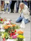  ?? JOHANNES SIMON / GETTY IMAGES ?? People mourn the slayings of nine people at a shopping center in Munich. Details about the gunman emerged Sunday.