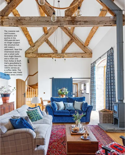  ??  ?? The massive oak roof trusses, tie-beams and purlins in the 450-year-old barn no longer support the structure but still make a statement. Near the Charnwood stove are a velvet sofa from Arighi Bianchi, and a linen one from Sofas & Stuff. Zoë’s grandfathe­r’s sea chest from the 1920s serves as a coffee table. The staircase was made by RM Jones Joinery