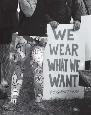  ?? THE ASSOCIATED PRESS ?? A woman joins others gathering at a starting point before marching for “yoga pants parade” in Barrington, R.I., Sunday.