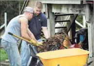  ??  ?? Ryan Howley, 31, left, and Chris Dennis, 26, both Danbury Police officers, volunteer to clean up the outside of Heidi Palmer's Danbury home Thursday, April 27, 2017. Dennis was required to take counseling and remedial training following an internal investigat­ion of a June 2021 incident at Danbury Library.