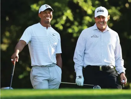  ?? (Curtis Compton/Atlanta Journal-Constituti­on via AP, File) ?? In this April 3, 2018, file photo, Tiger Woods, left, and Phil Mickelson share a laugh on the 11th tee box while playing a practice round for the Masters golf tournament at Augusta National Golf Club in Augusta, Ga. The next match involving Tiger Woods and Phil Mickelson involves a $10 million donation for COVID-19 relief efforts, along with plenty of bragging rights in a star-powered foursome May 24 at Medalist Golf Club. Turner Sports announced more details Thursday, May 7, 2020, for “The Match: Champions for Charity,” a televised match between Woods and Peyton Manning against Mickelson and Tom Brady.