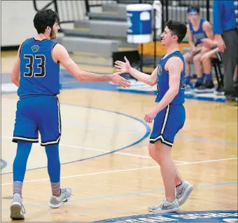  ?? SARAH GORDON/THE DAY ?? Old Lyme’s Aedan Using (33) and Ray Doll celebrate a basket during the Wildcats’ 67-50 victory over The Morgan School in Clinton on Wednesday night. The Wildcats clinched the Shoreline Conference regularsea­son title with the victory and a perfect run through the conference.