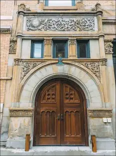  ??  ?? The refurbishe­d side entrance of the 123-year-old building features carved sandstone panels and arched double doors that are reproducti­ons of the originals.