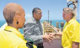  ?? FILE ?? In this July 19, 2019 photo, Chairman and CEO of New Fortress Energy Wes Edens (right) hosts Prime Minister Andrew Holness (centre), Energy Minister Fayval Williams (left) and others, aboard the company’s floating LNG terminal in Old Harbour, at its commission­ing.