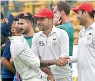  ?? R. SAMUEL ?? Shikar Dhawan (left) shares a light moment with the Afghanista­n players after the match. —