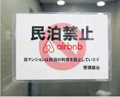  ??  ?? A sign communicat­ing the ban on using the apartment building as Airbnb service by the building management is attached to the building’s front door in Tokyo.