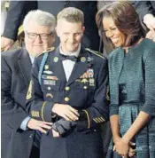  ?? OLIVIER DOULIERY/MCT ?? SFC Cory Remsburg stands with first lady Michelle Obama before the 2014 State of the Union speech.