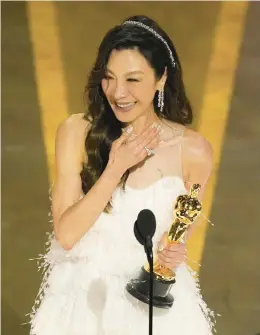  ?? ?? Michelle Yeoh accepts the award Sunday for lead actress for“everything Everywhere All at Once” in Los Angeles. She made history as the first Asian woman to win the best actress Oscar.
