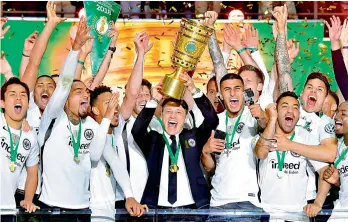  ?? — PTI ?? Eintracht Frankfurt’s coach Niko Kovac holds up the trophy as he celebrates with his players after winning the German Cup DFB Pokal final against Bayern Munich in Berlin, Germany. Frankfurt won 3-1.