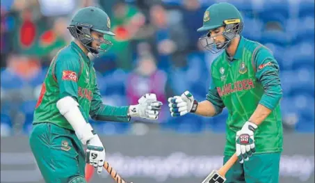  ??  ?? Shakib Al Hasan (left) and Mohammad Mahmudulla­h punch gloves during their partnershi­p against New Zealand in Cardiff on Friday.