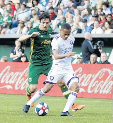  ?? SEAN MEAGHER/THE OREGONIAN ?? Orlando City’s Robinho vies for control of the ball Thursday against the Timbers.