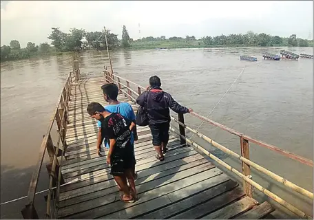  ?? KHUDORI/JAWA POS RADAR MOJOKERTO ?? BERBAHAN KAYU: Jembatan apung penghubung antardusun di Desa Tambakrejo, Kecamatan Ngoro, terputus setelah diterjang derasnya arus Sungai Porong kemarin.