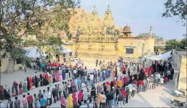  ?? HIMANSHU VYAS/HT PHOTO ?? Voters queue up at a polling booth in the backdrop of centuries-old temple spires and a mosque, in the historical township of Amber, in Jaipur district on Friday.