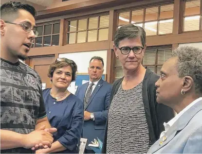  ?? FRAN SPIELMAN/SUN-TIMES ?? Library Commission­er Andrea Telli (second from the left) with Mayor Lori Lightfoot (right) and the mayor’s wife, Amy Eshleman (center), after unveiling the “Summer of Learning” program at McKinley Park library earlier this year.