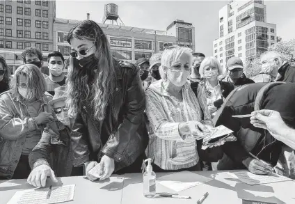  ?? Julia Gillard / New York Times ?? Volunteers organized by Dana Beal, members of the group Act Up and others hand out joints at Union Square in Manhattan on April 20 to people who could show that they were at least 21 and had received a COVID-19 vaccine.