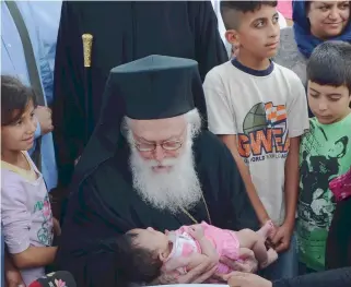  ??  ?? Archbishop Anastasios of Albania is seen during a visit over the summer to a refugee camp near Larissa in central Greece. In an interview with Kathimerin­i, Anastasios urged Greeks to look at reality candidly.