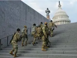  ?? PATRICK SEMANSKY/AP 2021 ?? National Guard soldiers climb a staircase toward the U.S. Capitol building before a rehearsal for then-President-elect Joe Biden’s inaugurati­on in Washington, D.C.