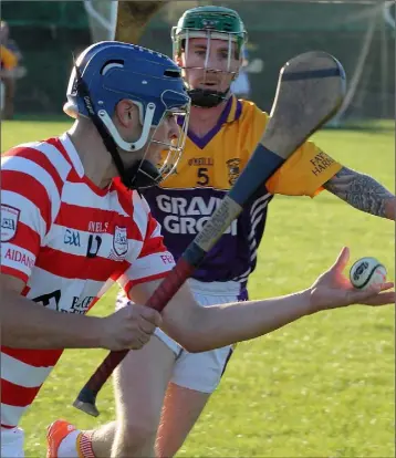  ??  ?? Ben Cowman (Ferns St. Aidan’s) about to strike as Fran Cleary (Faythe Harriers) moves in during their drawn Permanent TSB Junior hurling championsh­ip Group A game in Bree on Sunday.