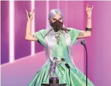  ?? Kevin Winter / MTV ?? Lady Gaga, above, wears a mask by Lance Victor Moore while accepting song of the year trophy at the 2020 MTV Video Music Awards show. Moore, left, holds a sketch for the “Trinity Crown.”