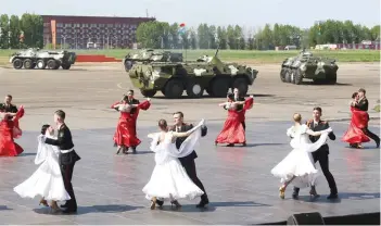  ?? — Reuters ?? Belarusian cadets dance with women during the opening ceremony of the 8th Internatio­nal Exhibition of Arms and Military Machinery “MILEX 2017” in Minsk, Belarus, on Saturday.