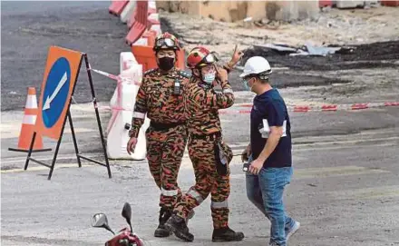  ?? BERNAMA PIC ?? Fire and Rescue Department personnel waiting for stabilisin­g work to be done before retrieving the body of the third worker at the constructi­on site of the Sungai Besi-Ulu Klang Elevated Expressway in Kuala Lumpur yesterday.