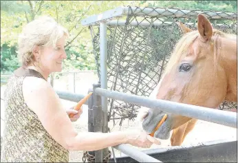  ?? Keith Bryant/The Weekly Vista ?? Renae Dudley, left, feeds Copper a carrot.