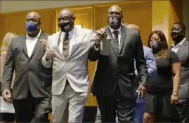  ?? David Joles/Star Tribune via AP ?? Floyd family attorney Ben Crump, center, walks in with George Floyd’s brothers Philonise Floyd, right, and Rodney Floyd, left, before they announced a $27 million civil lawsuit settlement on Friday.