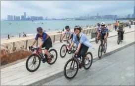  ?? SU BIKUN / FOR CHINA DAILY ?? Cyclists ride along the beautiful west coast of Binhai Road in Haikou, the capital city of Hainanprov­ince, on May 7.