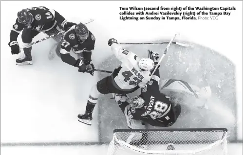  ??  ?? Tom Wilson (second from right) of the Washington Capitals collides with Andrei Vasilevski­y (right) of the Tampa Bay Lightning on Sunday in Tampa, Florida.