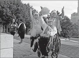  ??  ?? A mother and two daughters, all from Delaware, raise their arms in support as breast cancer surivors are acknowlege­d before the Making Strides walk. From left are Cortney Young, cancer survivor Margie Richert and Lisa Young.