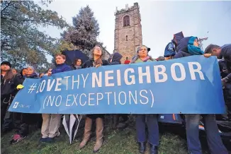  ?? GENE J. PUSKAR/ASSOCIATED PRESS ?? A group holds a sign Saturday during a memorial vigil in Pittsburgh for the victims of the shooting at the Tree of Life Synagogue.