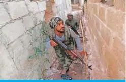  ?? — AFP ?? TADIF: Turkish-backed Syrian fighters cross between buildings in Tadef, near the city of AlBab, in the eastern countrysid­e of Aleppo province.