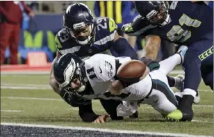  ?? PHOTO/JOHN FROSCHAUER ?? This Dec. 3 file photo shows Philadelph­ia Eagles quarterbac­k Carson Wentz (11) fumbling the ball near the goal line and into the end zone as Seattle Seahawks’ Earl Thomas (29) and Sheldon Richardson (91) move in during the second half of an NFL...