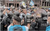  ?? SARAH PABST THE NEW YORK TIMES ?? A line of police tries to hold fans back near the Casa Rosada, the Argentine presidenti­al residence where former soccer superstar Diego Maradona’s body is lying in honour, at the Plaza de Mayo in Buenos Aires on Thursday.