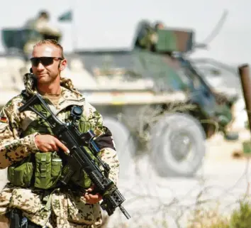  ?? Foto: Johannes Eisele, dpa ?? Ein bewaffnete­r Feldjäger der Bundeswehr steht im September 2007 in Kundus in der Sonne. In dieser Zeit wurde der Einsatz im‰ mer gefährlich­er. Doch von Krieg mochte in Deutschlan­d kaum jemand sprechen.